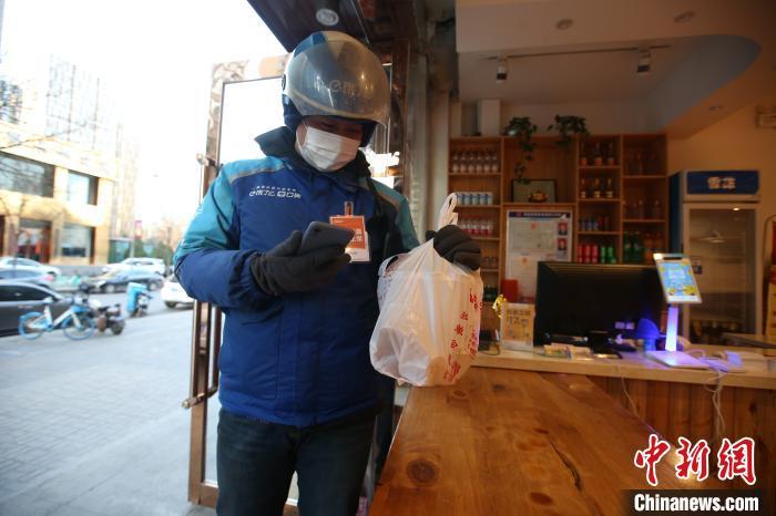 资料图：“饿了么”外卖员正在取餐。　张云 摄